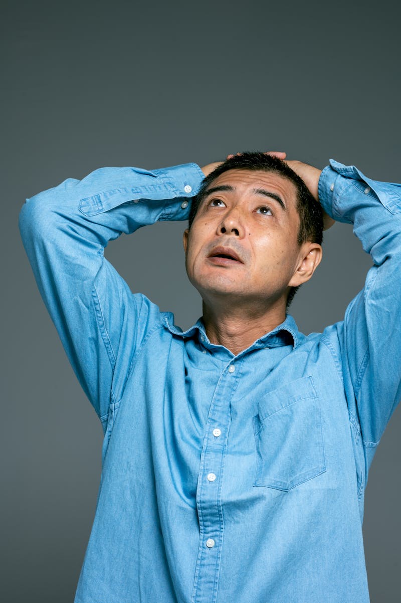 Man with hands on his head, looking frustrated